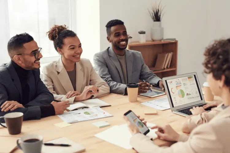 Reunião de trabalho com pessoas sorridentes.