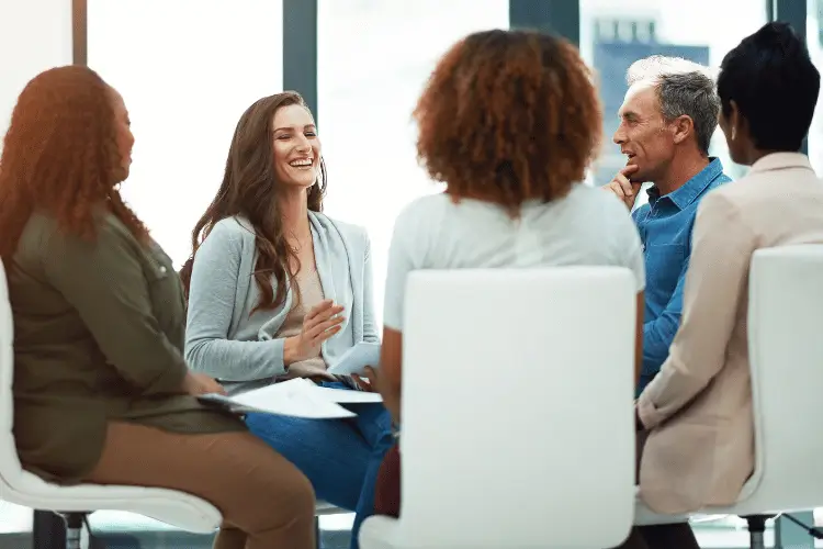 Reunião de trabalho com pessoas sorridentes.
