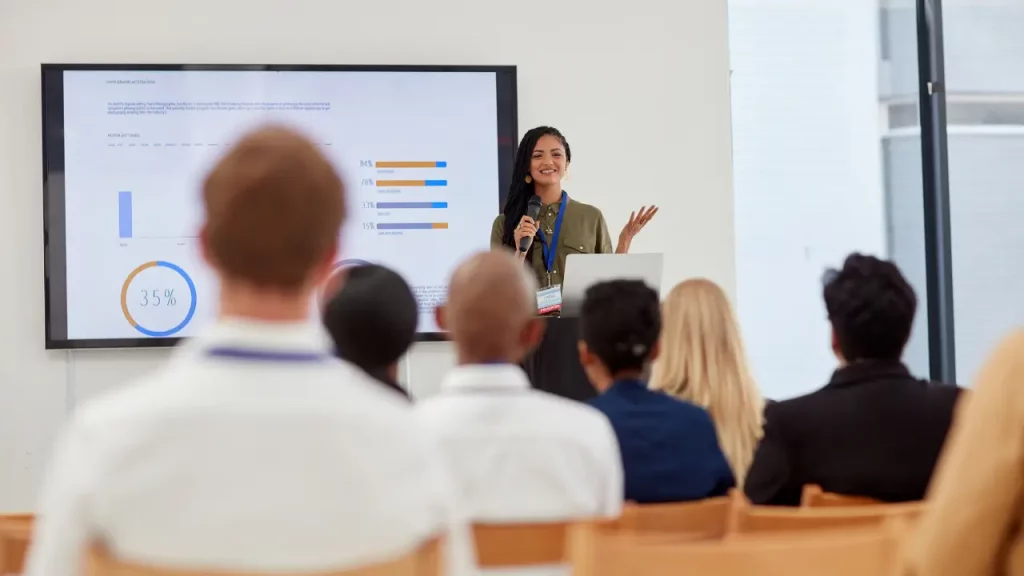 Mulher simulando matriz de comunicação para turma de alunos