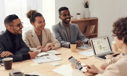 Reunião de trabalho com pessoas sorridentes.